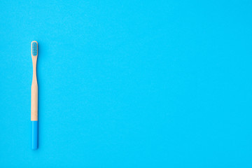 Toothbrush on blue background top view copy space. Tooth care, dental hygiene and health concept.