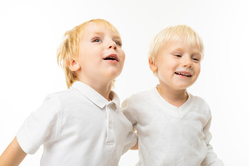 Two little caucasian brothers with blonde and fair red hair smiles, portrait isolated on white background