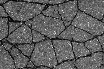 Fototapeta premium Damaged asphalt surface in black and white.