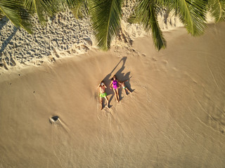 Fototapeta na wymiar Family lying down on beach aerial top view drone shot at Seychelles, Mahe
