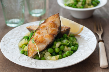 Pan Seared Halibut with Sauteed Peas and Lemon Wedge