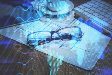 Financial chart hologram with glasses on the table background. Concept of business. Double exposure.