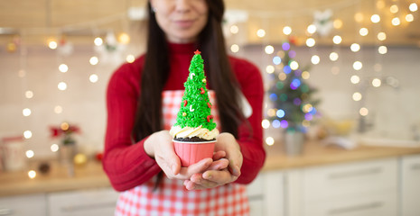 Girl prepares cupcakes in the form of Christmas trees.