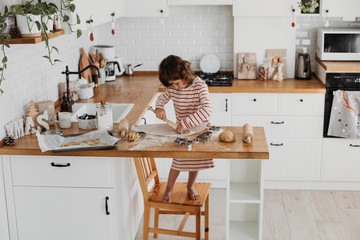 4 years cute girl making traditional Christmas cookies.