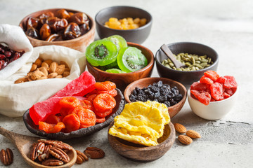 Variety of dry fruits and nuts in bowls. Healthy food concept, white background.