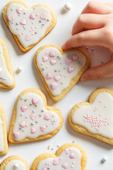Flat lay of cookies hearts with icing and decorated for Valentine's Day, white background. Valentine's day concept.