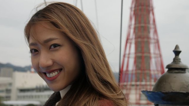 Smiling woman looking at camera while enjoying a boat cruse in Kobe Japan