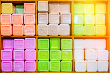 Colored soap stacked beautifully laid out in the store. French translation: Savon - soap