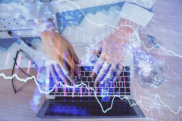 Double exposure of market chart with man working on computer on background. Concept of financial analysis.