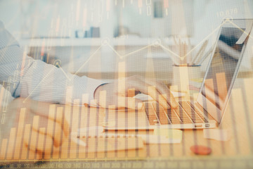 Multi exposure of stock market graph with man working on laptop on background. Concept of financial analysis.