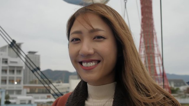 Close up of smiling happy Japanese woman enjoying boat cruse in Kobe port Japan