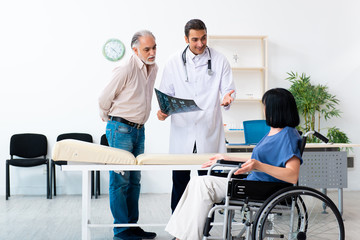 Fototapeta premium Old couple visiting young male doctor