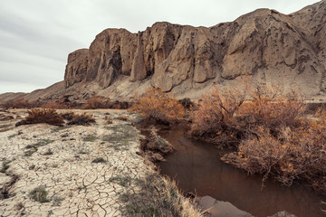 Small river in arid mountain terrain, atmospheric landscape