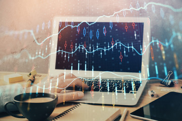 Forex graph with businessman working on computer in office on background. Concept of hardworking. Double exposure.