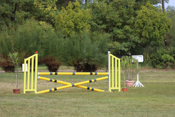 Obraz na płótnie Canvas Colorful barriers on the ground for jumping horses and riders at riding school as a background.Obstacles for horses in a riding school