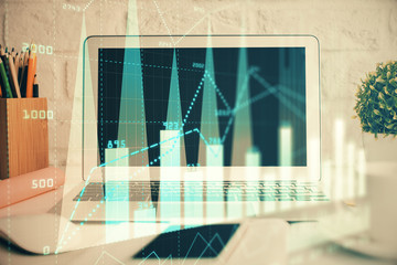 Forex graph hologram on table with computer background. Multi exposure. Concept of financial...