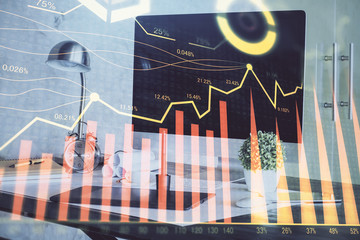 Stock market chart hologram drawn on personal computer background. Double exposure. Concept of...