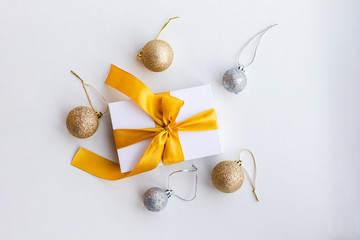 Paper gift box wrapped with yellow ribbon with Christmas decorations, isolated on white background top view. Presents and holidays concept.