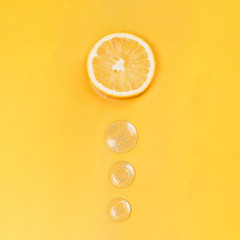 Orange slice and round drops on an orange background medical concept