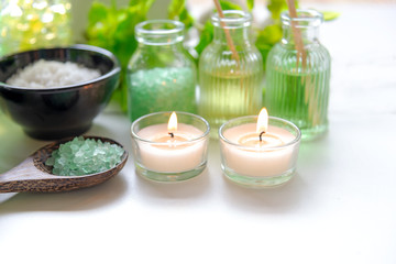 Obraz na płótnie Canvas Thai Spa Treatments aroma therapy salt and nature green sugar scrub and rock massage with green orchid flower on wooden white with candle. Thailand. Healthy Concept.
