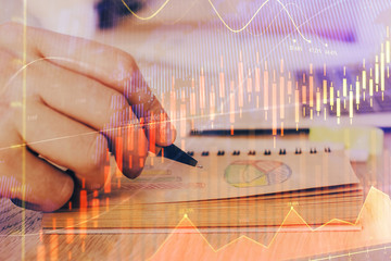 Multi exposure closeup hands with stock market forex graph.