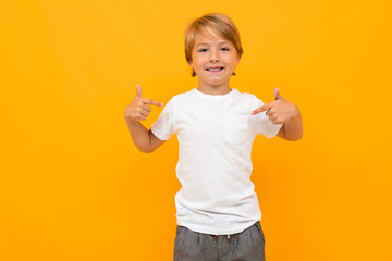 attractive european boy in a white t-shirt with mockup on an orange background with copy space