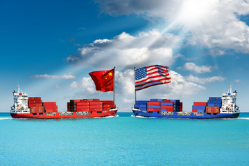 USA and China trade war concept. Two cargo container ships with the Chinese and United states of America flag, in a turquoise sea with blue sky, clouds and sun rays