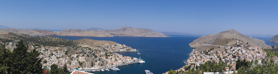 Fototapeta na wymiar A panoramic view of the port of the Greek island of Symi. Picture taken at height from the mountains that encircle the bay.