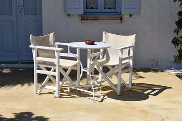 Table and chairs at a pavement cafe on the charming Greek island of Folegandros on a summers day.