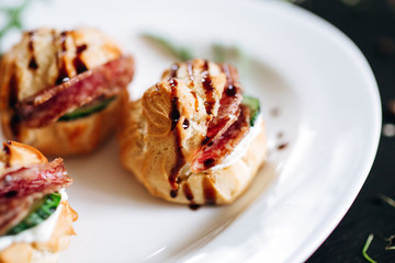 Cheese donuts with salami and cucumbers under balsamic sauce. Catering