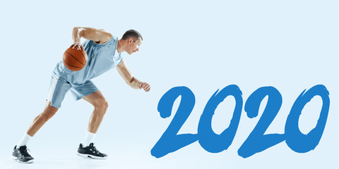 2020 Year meeting. Young caucasian basketball player in action, motion in jump isolated on blue background. Concept of sport, movement, energy and dynamic, healthy lifestyle. Training. Flyer for ad.