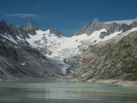 Alpine valley with lake, glacier and sharp peaks
