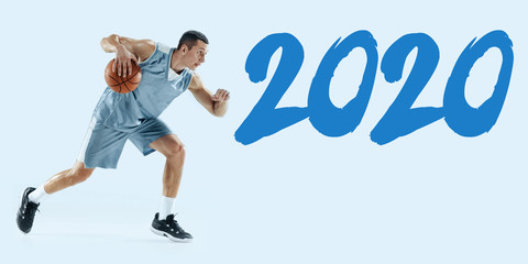 2020 Year meeting. Young caucasian basketball player in action, motion in jump isolated on blue...
