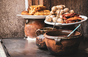 Guatemalan street food prepared in clay pots on the street in Antigua Guatemala.