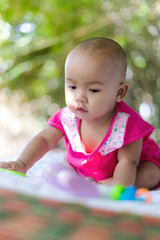 Cute little Asian baby sitting and play with happiness select focus shallow depth of field