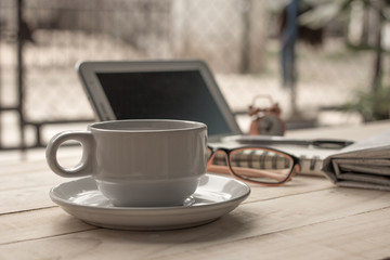 Vintage cup of coffee and a newspaper on the table.