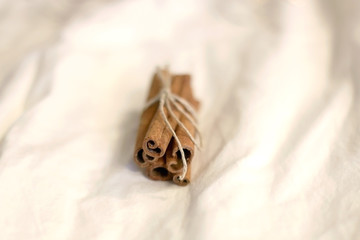 Cinnamon sticks on white background with bokeg lights. Selective focus.