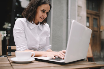 Young businesswoman working in cafe. Beautiful woman having a video call in coffee shop.