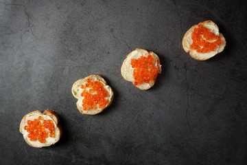 Sandwiches with red caviar on a dark background. Seafood, healthy food