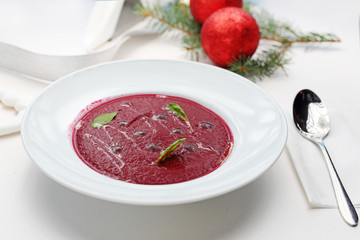 Beet cream soup, Christmas festive soup. Christmas dishes, traditional Christmas food. A composition of dishes on a Christmas table. Horizontal, top view