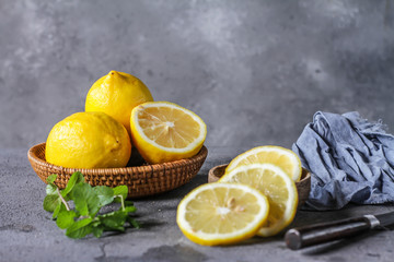 Photo of fresh ripe lemons on dark background. A slice of lemon with green leaves. Lemon fruit on...