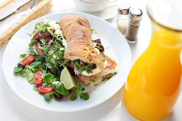 Sandwich with ham and vegetables. Roll sandwich served with ham and vegetables. appetizing nutritious breakfast.