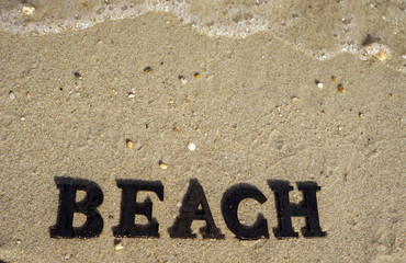the word beach in the sand