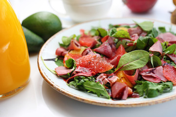 Salad. Green lettuce with grapefruit, orange and ham served with vinaigrette sauce.