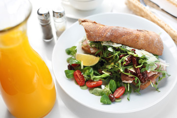 Sandwich with ham and vegetables. Roll sandwich served with ham and vegetables. appetizing nutritious breakfast.