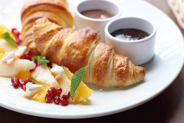 Breakfast. Crunchy croissant, chocolate, jam and fresh fruit salad.