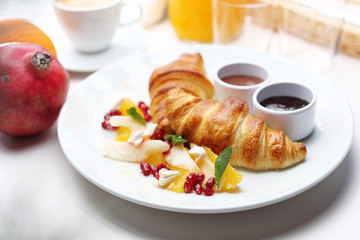 Sweet breakfast, tasty fresh bread with toppings. Buttery croissant, chocolate, jam and fresh fruit salad.