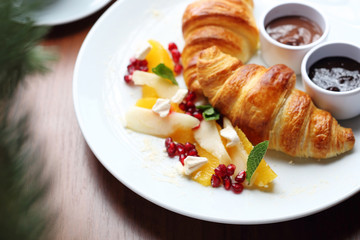 Buttery croissant, chocolate, jam and fresh fruit salad.
