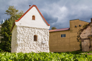 Low-angle view of the House of Merchant Guild of Holy Spirit lit by the sun on the background of a thundercloud, Vyborg, Leningrad Oblast, Russia © dr_verner