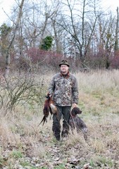 Hunter and German pointer carries pheasants